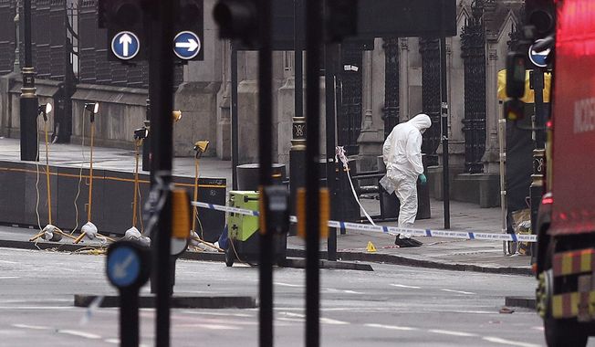 A forensic officer works near the Houses of Parliament in London, Britain, the day after a terrorist attack, Thursday March 23, 2017. A knife-wielding man went on a deadly rampage in the heart of Britain&#x27;s seat of power Wednesday, plowing a car into pedestrians on London&#x27;s Westminster Bridge before stabbing a police officer to death inside the gates of Parliament. Five people were killed, including the assailant. (Jonathan Brady/PA via AP)
