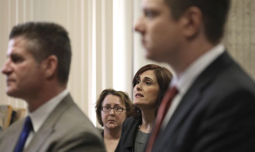 City of Chicago Attorney Lisette Mojica, second from right, answers questions from Judge Vincent Gaughan while standing with defense attorney Dan Herbert, left and defendant former Chicago Police Officer Jason Van Dyke, during a hearing at the Leighton Criminal Courts Building Thursday, March 23, 2017 in Chicago. A grand jury has added 16 counts of aggravated battery with a firearm to the first-degree murder charges against Van Dyke accused in the 2014 fatal shooting of a black 17-year-old. (Nancy Stone/Chicago Tribune via AP, Pool)