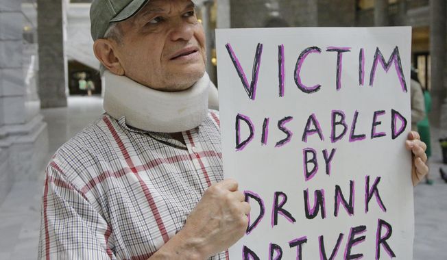 FILE - In this March 17, 2017, file photo, Ed Staley holds a sign during a rally at the Utah State Capitol in Salt Lake City. Utah's governor has announced he will sign legislation giving the state the strictest DUI threshold in the country. Republican Gov. Gary Herbert on Thursday, March 23, 2017, said he plans to approve the measure lowering the blood alcohol limit to .05 percent from .08 percent. Restaurant groups and representatives of the ski and snowboard industry had urged him to veto the bill, arguing it would hurt Utah's image. (AP Photo/Rick Bowmer, File)