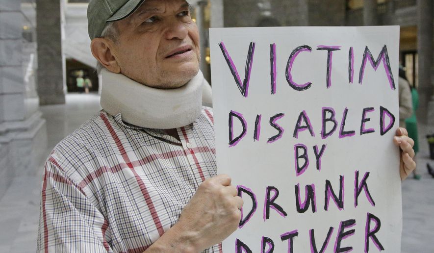 FILE - In this March 17, 2017, file photo, Ed Staley holds a sign during a rally at the Utah State Capitol in Salt Lake City. Utah's governor has announced he will sign legislation giving the state the strictest DUI threshold in the country. Republican Gov. Gary Herbert on Thursday, March 23, 2017, said he plans to approve the measure lowering the blood alcohol limit to .05 percent from .08 percent. Restaurant groups and representatives of the ski and snowboard industry had urged him to veto the bill, arguing it would hurt Utah's image. (AP Photo/Rick Bowmer, File)