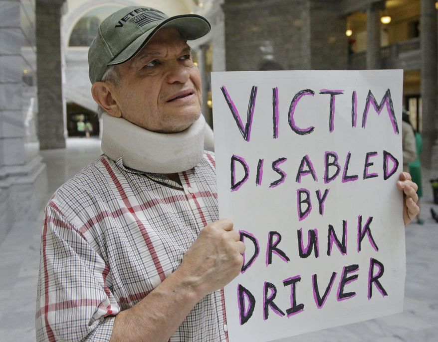 FILE - In this March 17, 2017, file photo, Ed Staley holds a sign during a rally at the Utah State Capitol in Salt Lake City. Utah's governor has announced he will sign legislation giving the state the strictest DUI threshold in the country. Republican Gov. Gary Herbert on Thursday, March 23, 2017, said he plans to approve the measure lowering the blood alcohol limit to .05 percent from .08 percent. Restaurant groups and representatives of the ski and snowboard industry had urged him to veto the bill, arguing it would hurt Utah's image. (AP Photo/Rick Bowmer, File)