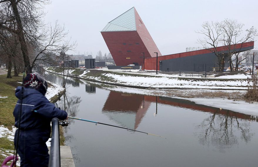 FILE -In this file photo taken in Gdansk, Poland, Jan. 23, 2017, a woman fishes near the Museum of the Second World War, an ambitious new museum under creation for nine years. It opened to visitors on Thursday, March 23, 2017, amid plans by the conservative government to change its content to fit its nationalist views. (AP Photo/Czarek Sokolowski, File)