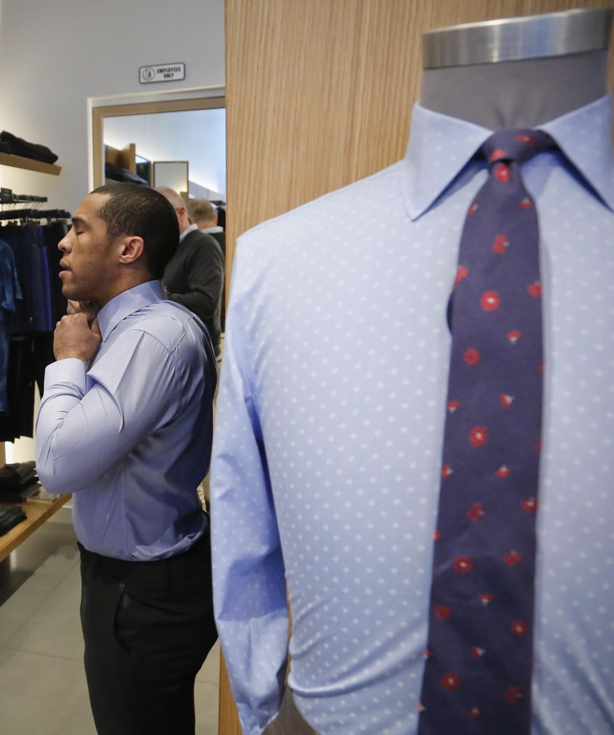 In this Monday, March 20, 2017, photo, J.P. Grant, a financial consultant, fits a shirt at Bonobos' Guideshop, as he shops for clothing during his lunch break, in New York's Financial District. "This was the first place I thought of," said Grant. "Convenience...definitely. I order the product in-store and they send to your residence or wherever you are." (AP Photo/Bebeto Matthews)