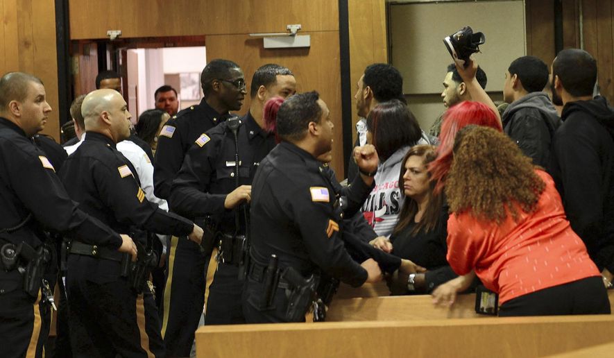 Police attempt to quell an argument between relatives of the victims and suspects after Clarence Williams and Gerry Thomas made their appearances for murder, Friday, March 24, 2017, in Paterson, N.J., in a double homicide involving a burning car owned by a woman who often appears on "Real Housewives of New Jersey." (Tariq Zehawi /The Record via AP, Pool)