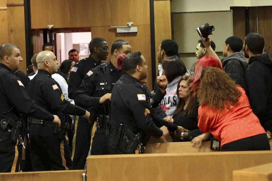 Police attempt to quell an argument between relatives of the victims and suspects after Clarence Williams and Gerry Thomas made their appearances for murder, Friday, March 24, 2017, in Paterson, N.J., in a double homicide involving a burning car owned by a woman who often appears on "Real Housewives of New Jersey." (Tariq Zehawi /The Record via AP, Pool)