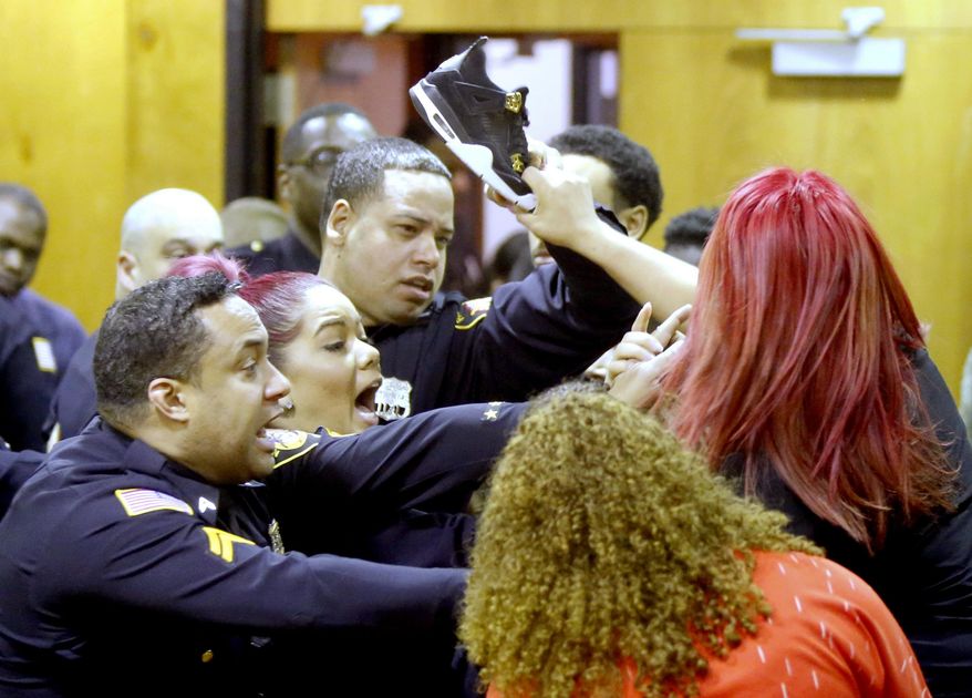 Sheriff's Deputies keep Debora Hernandez, right, the mother of Antonio Vega's daughter, from hitting a defendant's family member with her shoe after an altercation between the two groups broke out at the end of a hearing where Clarence Williams and Gerry Thomas made their appearances for murder, Friday, March 24, 2017, in Paterson, N.J. The two Paterson residents have been charged with murder in a double homicide involving a burning car owned by a woman who often appears on "Real Housewives of New Jersey." The pair are charged with killing Aaron Anderson and Antonio Vega Jr., who were found last week inside a burning 2015 Audi. (Aristide Economopoulos /NJ Advance Media via AP, Pool)
