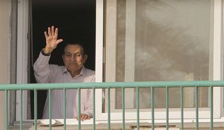 FILE - In this Oct. 16, 1016 file photo, ousted Egyptian President Hosni Mubarak waves to his supporters from his room at the Maadi Military Hospital as they celebrate the 43rd anniversary of the Oct. 6, 1973 war. An Egyptian security official said Froday, March 24, 2017 that the country’s ousted President Hosni Mubarak returned home, after his release. (AP Photo/Amr Nabil, File)