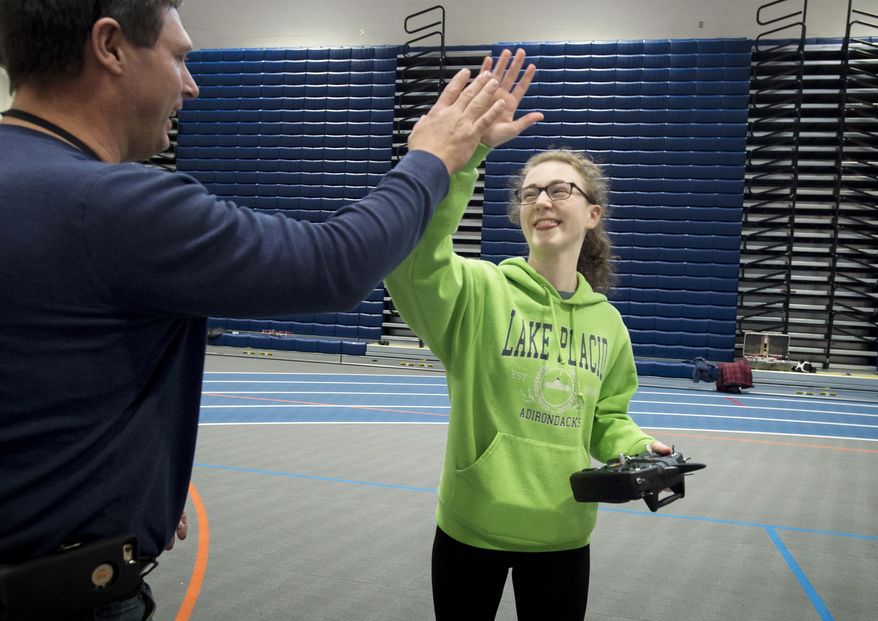 FOR RELEASE SATURDAY, MARCH 25, 2017, AT 9:00 A.M. EDT.-E.C. Glass student Erin McCarthy high fives instructor David Childress after successfully flying her drone for the first time on Friday, March 3, 2017 in Lynchburg, Va. The students used their intersession week off of school to build the drones. (Jill Nance/News & Daily Advance via AP)