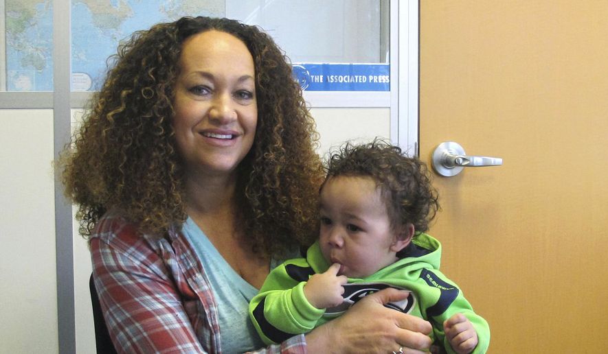 In this March 20, 2017, photo, Rachel Dolezal poses for a photo with her son, Langston in the bureau of The Associated Press in Spokane, Wash. Dolezal, who has legally changed her name to Nkechi Amare Diallo, rose to prominence as a black civil rights leader, but then lost her job when her parents exposed her as being white and is now struggling to make a living. (AP Photo/Nicholas K. Geranios)