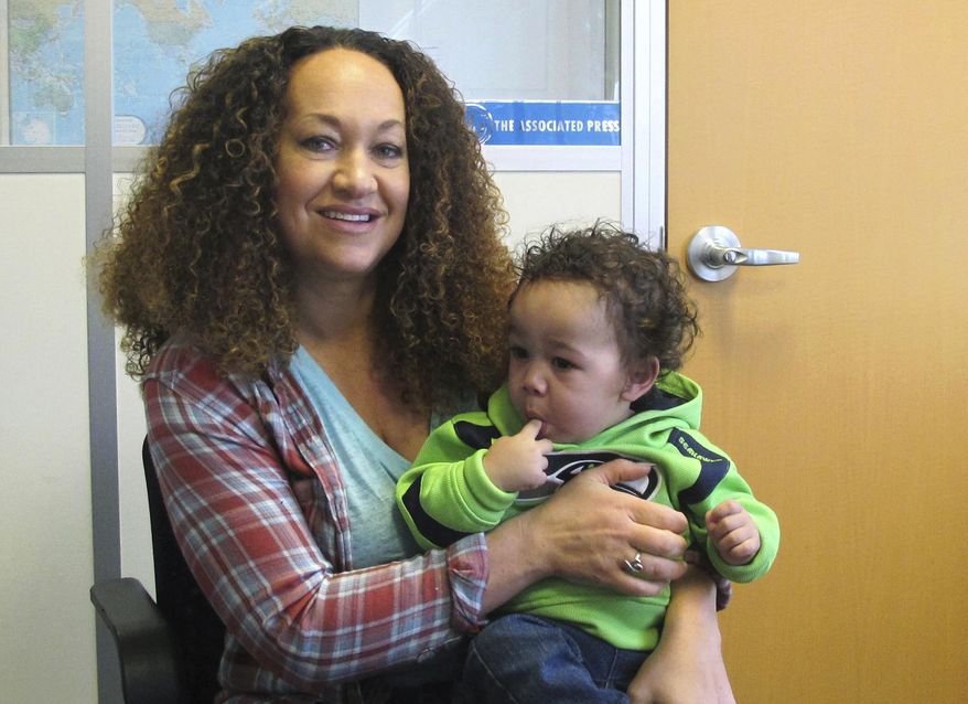 In this March 20, 2017, photo, Rachel Dolezal poses for a photo with her son, Langston in the bureau of The Associated Press in Spokane, Wash. Dolezal, who has legally changed her name to Nkechi Amare Diallo, rose to prominence as a black civil rights leader, but then lost her job when her parents exposed her as being white and is now struggling to make a living. (AP Photo/Nicholas K. Geranios)
