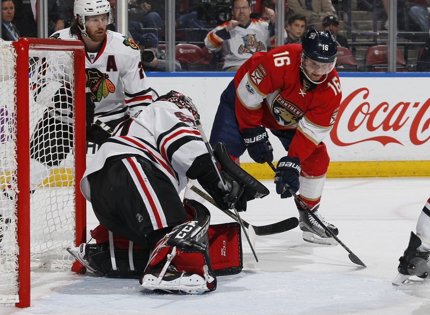 Chicago Blackhawks goaltender Corey Crawford (50) stops a shot by Florida Panthers center Aleksander Barkov (16) during the first period of an NHL hockey game, Saturday, March 25, 2017, in Sunrise, Fla. (AP Photo/Joel Auerbach)