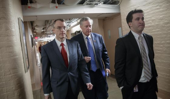 House Freedom Caucus Chairman Rep. Mark Meadows, R-N.C., center, whose conservative faction of the GOP bucked the Republican health care bill, heads to caucus meeting in the basement of the Capitol before House Speaker Paul Ryan, R-Wis., announces that he is abruptly pulling their troubled health care bill off the House floor, in Washington, Friday, March 24, 2017. (AP Photo/J. Scott Applewhite)