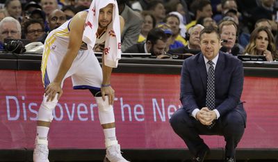 Golden State Warriors' Stephen Curry, left, watches the second half of an NBA basketball game beside Sacramento Kings coach Dave Joerger, Friday, March 24, 2017, in Oakland, Calif. (AP Photo/Ben Margot)
