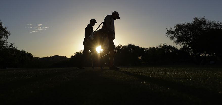 Jon Rahm, left, of Spain, and his caddie walk off off the tee box on the first hole during the round of 16 play at the Dell Technologies Match Play golf tournament at Austin County Club, Saturday, March 25, 2017, in Austin, Texas. (AP Photo/Eric Gay)