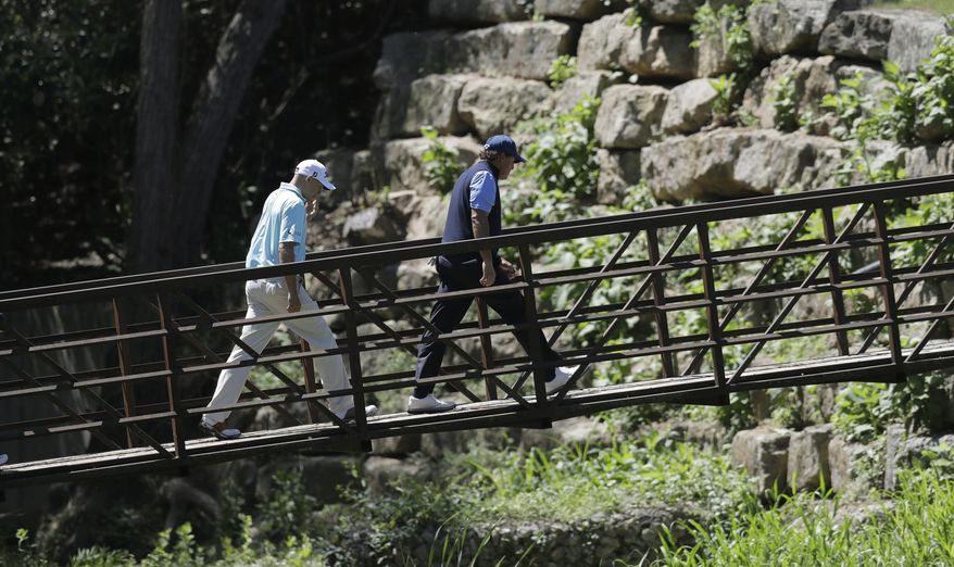 Phil Mickelson, right, is followed by Bill Haas as they cross a bridge and head to the fourth green during quarterfinal play at the Dell Technologies Match Play golf tournament at Austin County Club, Saturday, March 25, 2017, in Austin, Texas. (AP Photo/Eric Gay)