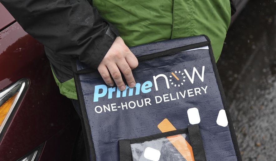 Amazon Flex driver James Fowler holds an empty Amazon bag he uses for cold goods next to his car in Vancouver, Wash., Monday, March 13, 2017. He earns $18 to $25 per hour working through the service, delivering packages and other goods. (Ariane Kunze/The Columbian via AP)