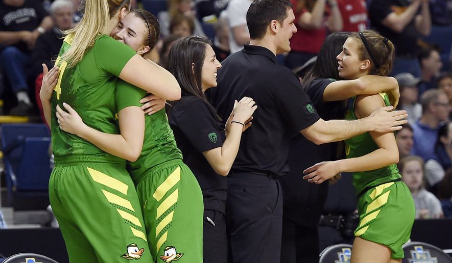 Oregon's Sabrina Ionescu, second from left, is embraced by teammate Mallory McGwire as she comes off the bench during the second half of a regional semifinal game against Maryland in the NCAA women's college basketball tournament, Saturday, March 25, 2017, in Bridgeport, Conn. (AP Photo/Jessica Hill)