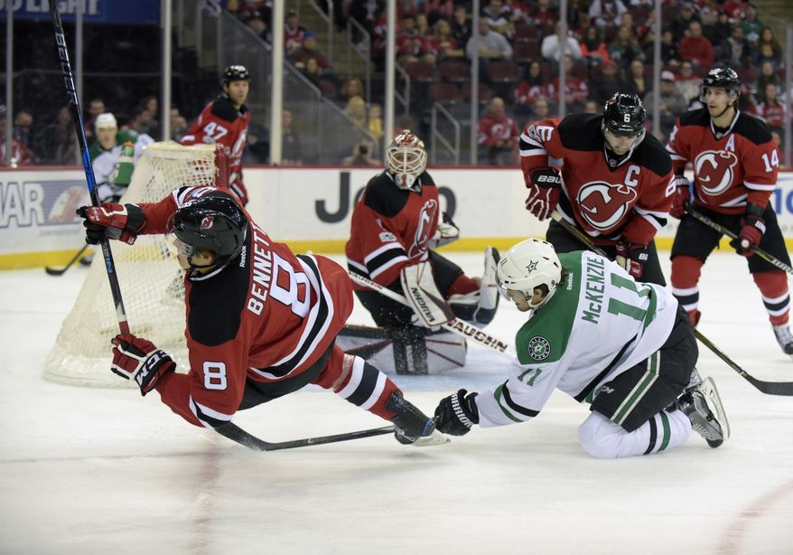New Jersey Devils right wing Beau Bennett (8) is tripped by Dallas Stars left wing Curtis McKenzie (11) during the first period of an NHL hockey game Sunday, March 26, 2017, in Newark, N.J. (AP Photo/Bill Kostroun)