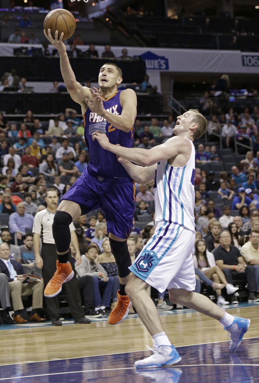 Phoenix Suns' Alex Len (21) drives past Charlotte Hornets' Cody Zeller (40) in the first half of an NBA basketball game in Charlotte, N.C., Sunday, March 26, 2017. (AP Photo/Chuck Burton)