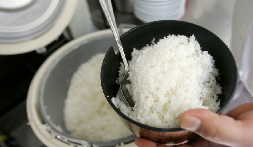 Frank Chu, manager of San Tung Chinese restaurant, scoops a bowl of rice for customers in San Francisco on April 25, 2008. (Associated Press) **FILE**