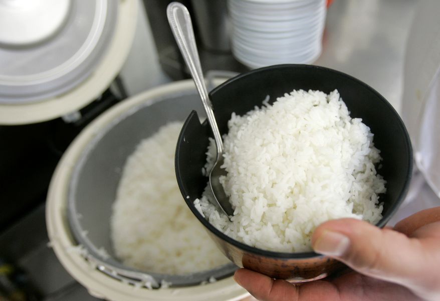 Frank Chu, manager of San Tung Chinese restaurant, scoops a bowl of rice for customers in San Francisco on April 25, 2008. (Associated Press) **FILE**