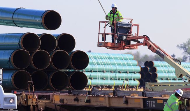 FILE - In this May 9, 2015 file photo, workers unload pipes at a staging area in Worthing, S.D., for the proposed Dakota Access Pipeline that would stretch from the Bakken oil fields in North Dakota through South Dakota and Iowa to a hub in Illinois. On Monday, Nov. 30, 2015, the South Dakota Public Utilities Commission is meeting to discuss whether to grant a construction permit for the 1,130-mile pipeline that would move at least 450,000 barrels of crude daily from the Bakken oil patch. (AP Photo/Nati Harnik, File)