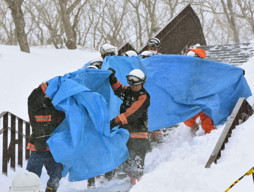 Rescuers carry the people who got injured in an avalanche at a ski resort in Nasu, Tochigi prefecture, Monday, March 27, 2017. Authorities said six Japanese high school students have been found unconscious after they were caught in the avalanche Monday morning. (Kyodo News via AP)