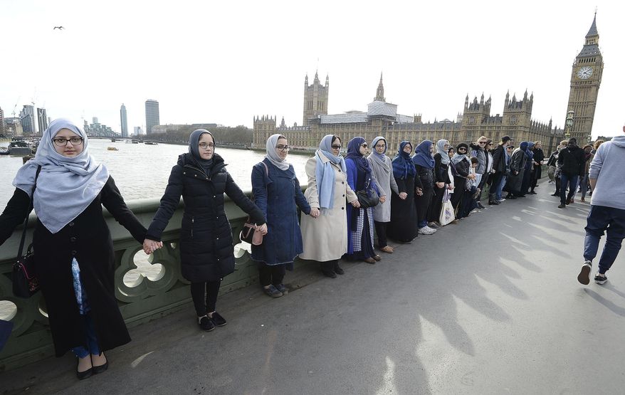 A group of women, some with their daughters, link hands on Westminster bridge in central London in an act of solidarity organised by Women's March London to pay tribute to the victims of the Westminster attack, Sunday March 26, 2017. (John Stillwell/PA via AP)
