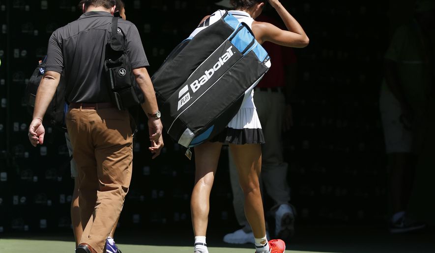 Garbine Muguruza, of Spain, leaves the court after she retired from a tennis match against Caroline Wozniacki, of Denmark, at the Miami Open, Monday, March 27, 2017 in Key Biscayne, Fla. (AP Photo/Wilfredo Lee)