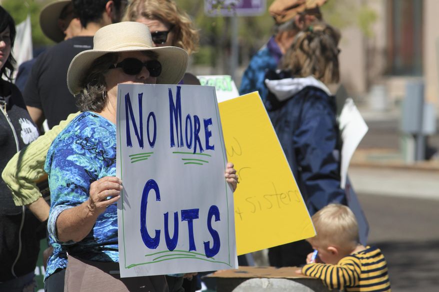 Linda White, left, of Albuquerque, N.M., is among protesters who lined a sidewalk outside a luncheon attended by Gov. Susana Martinez in Albuquerque, on Monday, March 27, 2017. White said she was concerned that New Mexico could not afford to make any more cuts to government programs as Martinez and state lawmakers are engaged in a standoff over the budget and millions of dollars in tax increases. (AP Photo/Susan Montoya Bryan)