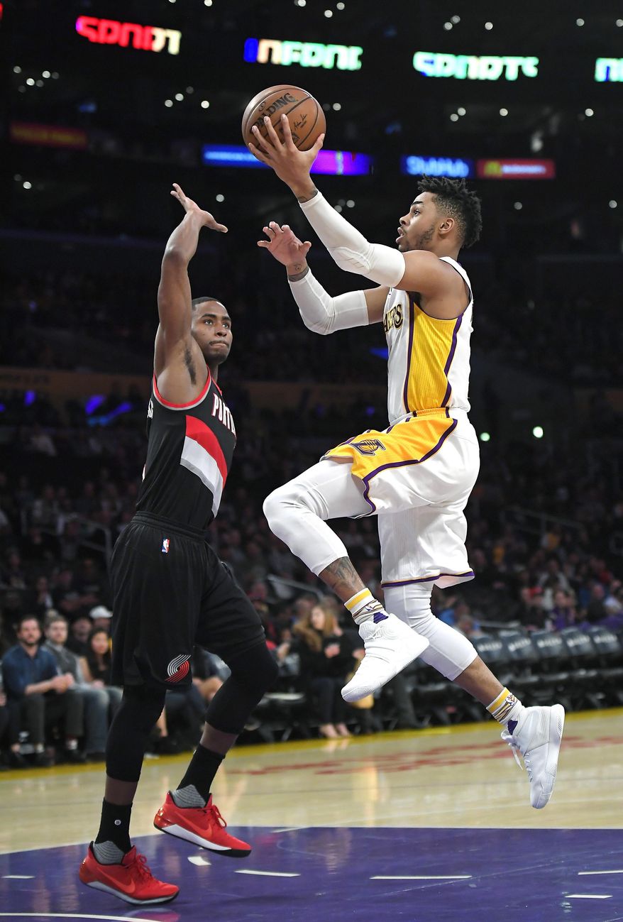 Los Angeles Lakers guard D'Angelo Russell goes to the basket as Portland Trail Blazers forward Maurice Harkless defends during the first half of an NBA basketball game, Sunday, March 26, 2017, in Los Angeles. (AP Photo/Mark J. Terrill)
