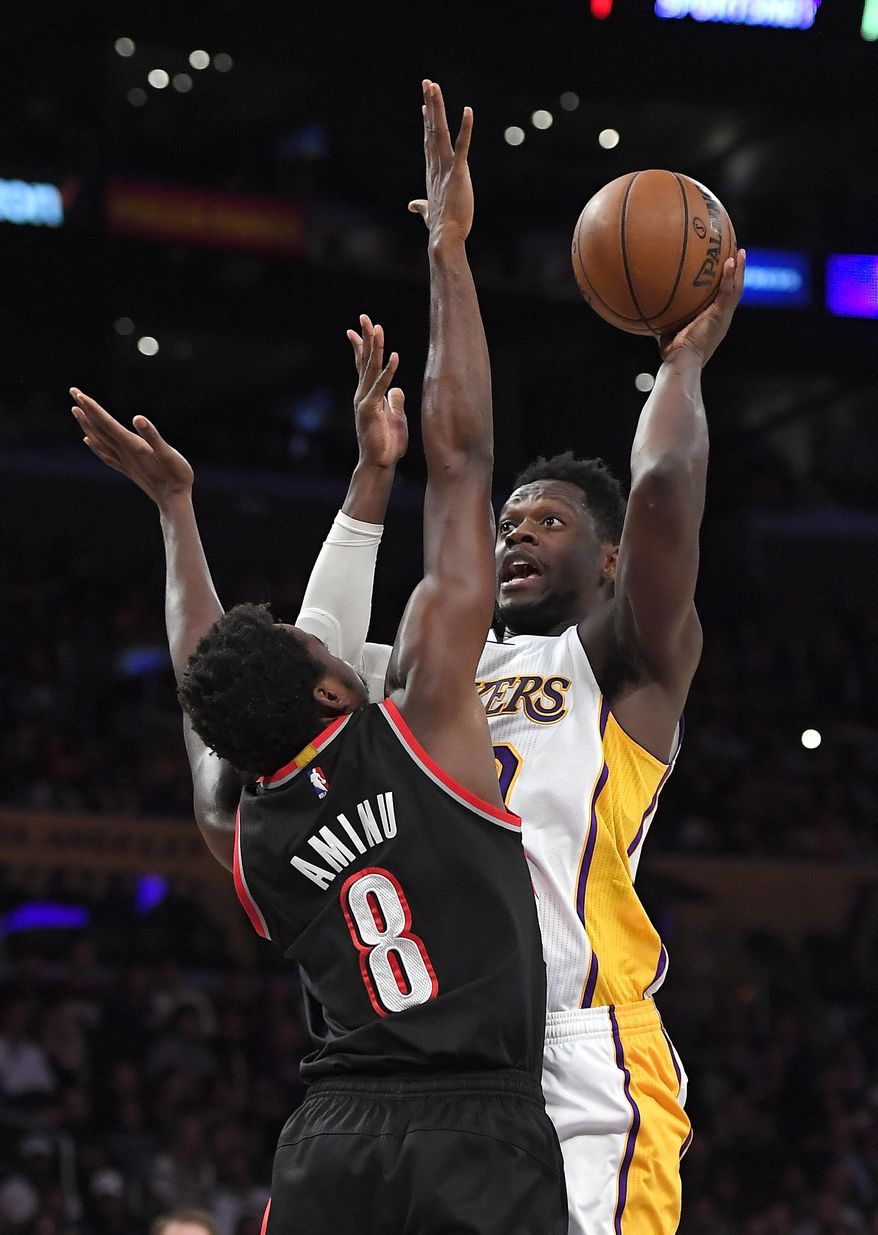 Los Angeles Lakers forward Julius Randle, right, shoots as Portland Trail Blazers forward Al-Farouq Aminu defends during the first half of an NBA basketball game, Sunday, March 26, 2017, in Los Angeles. (AP Photo/Mark J. Terrill)