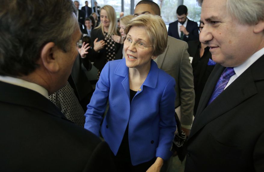U.S. Sen. Elizabeth Warren, D-Mass., center, greets business leaders during a New England Council luncheon at a hotel, Monday, March 27, 2017, in Boston. Larry Zabar, New England Council executive vice president, looks on at right. (AP Photo/Steven Senne)