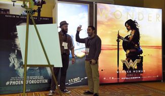 Drew Lawrence, left, and Joey Paur film a segment for their web show &amp;quot;Geek Tyrant&amp;quot; in front of an advertisement for the upcoming film &amp;quot;Wonder Woman&amp;quot; during CinemaCon 2017 at Caesars Palace on Monday, March 27, 2017, in Las Vegas. (Photo by Chris Pizzello/Invision/AP)