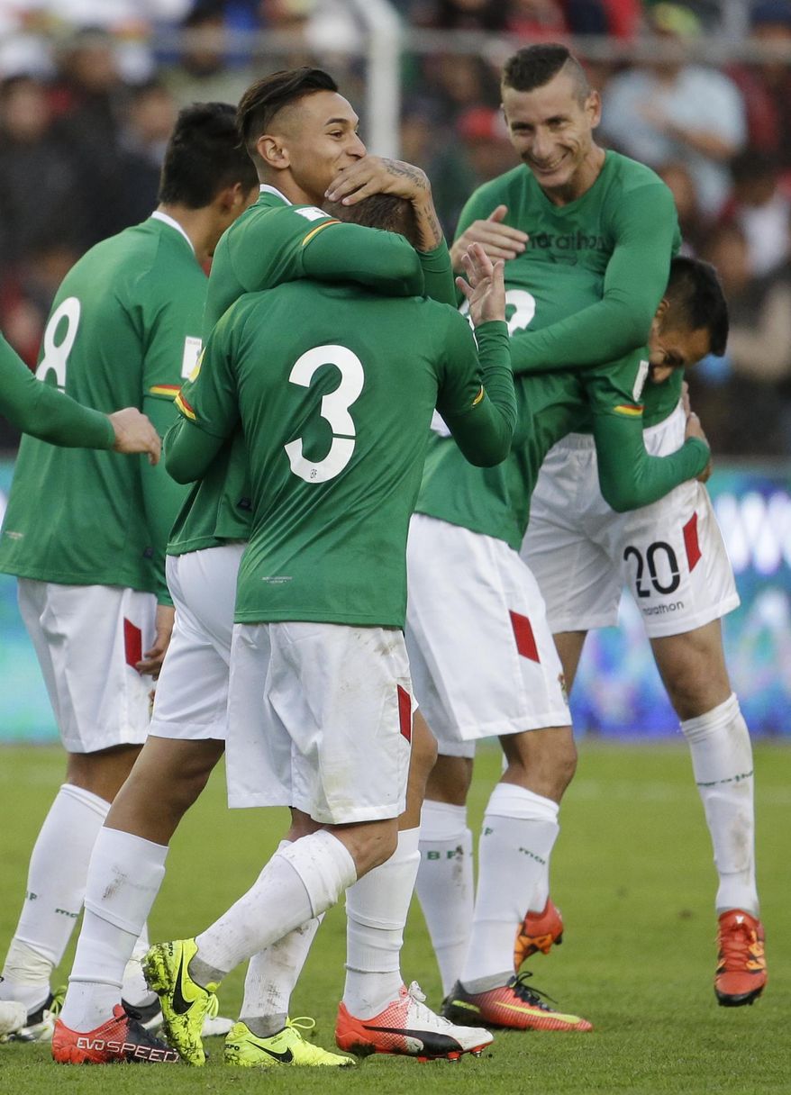 Bolivia's Bruno Miranda embraces Bolivia's Alejandro Chumacero (3) as they celebrate with teammates defeating Argentina 2-0 during a 2018 World Cup qualifying soccer match in La Paz, Bolivia, on Tuesday, March 28, 2017. (AP Photo/Victor R. Caivano)