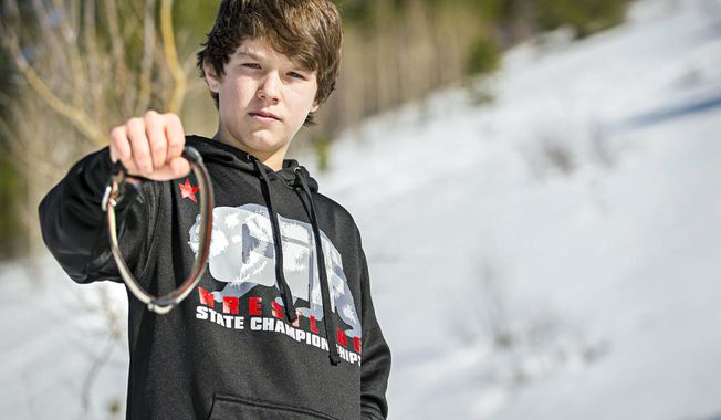 In this March 17, 2017 photo, Canyon Mansfield, 14, holds the collar of his dog, Casey, who was killed March 16 by a cyanide-ejecting device placed on public land near his Pocatello, Idaho, home by federal workers to kill coyotes. The cyanide device, called an M-44, is spring-activated and shoots poison that is meant to kill predators. The U.S. Department of Agriculture in November said it would not put the devices on public land in Idaho. (Jordon Beesley/Idaho State Journal via AP)