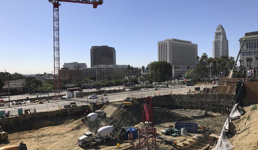 A construction site is seen in downtown Los Angeles Tuesday, March 28, 2017. Authorities say a woman has climbed a construction crane and locked herself inside the operator's cabin. Police say the woman somehow made her way up the towering red crane Tuesday afternoon. The Fire Department says workers turned off the crane power so she can't move it. (AP Photo/Damian Dovarganes)