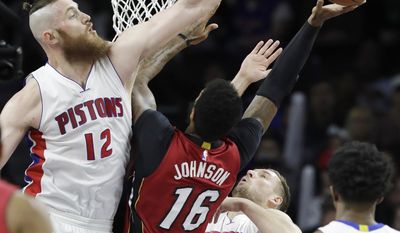 Detroit Pistons center Aron Baynes (12) attempts a block on Miami Heat forward James Johnson (16) during the first half of an NBA basketball game, Tuesday, March 28, 2017, in Auburn Hills, Mich. (AP Photo/Carlos Osorio)