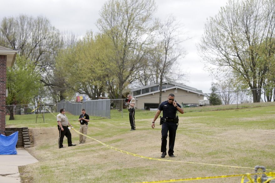 Wagoner county and Broken Arrow law enforcement officers investigate the scene of a failed robbery that led to the death of the three robbers in Broken Arrow, Okla., on Monday, March 27, 2017. Police say they have arrested a woman suspected of driving the vehicle used by three men who were attempting to rob a home and were shot to death by the homeowner's son. (Ian Maule/Tulsa World via AP)