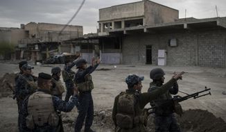 Federal Police soldiers gesture to other soldiers near the old city, during fighting against Islamic State militants on the western side of in Mosul, Iraq, Tuesday, March 28, 2017. (AP Photo/Felipe Dana)