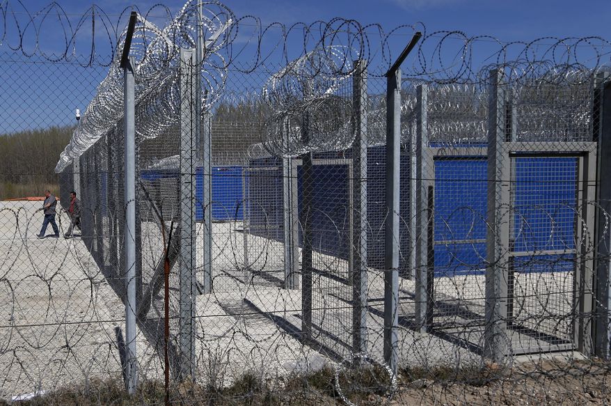 Hungarian workers leave a container camp at Serbia's border with Hungary near a makeshift camp for migrants in Horgos, Serbia, Tuesday, March 28, 2017. Hungary's new legislation allowing for the placement of all asylum-seekers in border container camps took effect Tuesday, with the European Union's commissioner for migration saying that it needs to comply with the bloc's rules. (AP Photo/Darko Vojinovic)