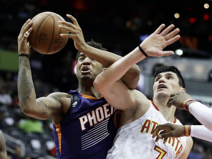 Phoenix Suns' Marquese Chriss, left, grabs a rebound from Atlanta Hawks' Ersan Ilyasova, of Turkey, in the second quarter of an NBA basketball game in Atlanta, Tuesday, March 28, 2017. (AP Photo/David Goldman)