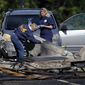 FILE - In this Oct. 12, 2016 file photo, investigators look at the remains of a small plane along Main Street in East Hartford, Conn. Police say the student pilot of the small plane, which crashed on Oct. 11, near the Connecticut headquarters of a military jet engine manufacturer, fought with his instructor and probably crashed deliberately. East Hartford police reports disclosed Tuesday, March 28, 2017, support media stories from months ago. (AP Photo/Jessica Hill, File)