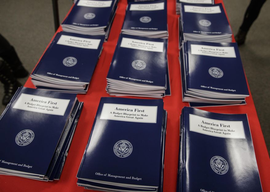 FILE - In this March 16, 2017 file photo, copies of President Donald Trump's first budget are displayed at the Government Printing Office in Washington. resident Donald Trump is proposing immediate budget cuts of $18 billion from programs like medical research, infrastructure and community grants so U.S. taxpayers, not Mexico, can cover the downpayment on the border wall. (AP Photo/J. Scott Applewhite, File)