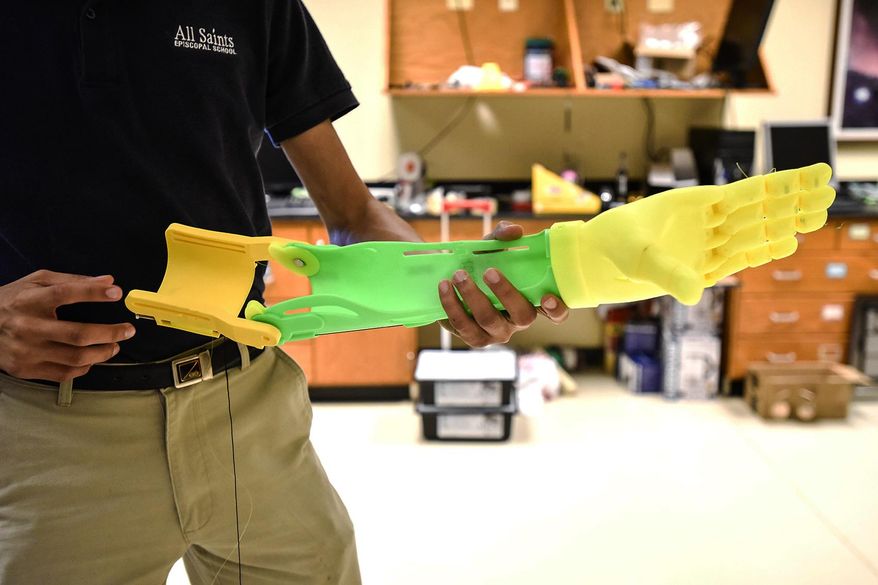 ADVANCE FOR MONDAY APRIL 3 AND THEREAFTER - In a Tuesday, March 21, 2017 photo, Kevin Scott holds a 3-D-printed prosthetic prototype at All Saints Episcopal School in Tyler, Texas. The students are part of a group making a prosthetic arm and hand in partnership with the Center for Affordable Prosthetics that will eventually be used by Osman, a 22-year-old man who lives in Honduras. (Chelsea Purgahn/Tyler Morning Telegraph via AP)