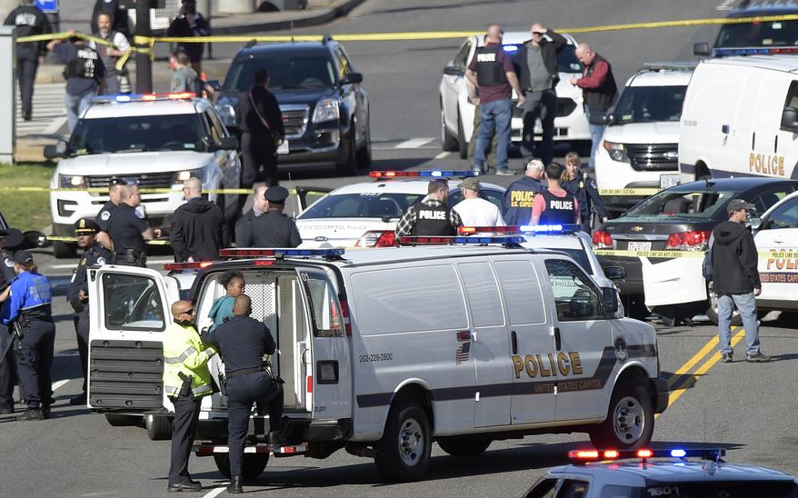 A woman, center, is taken into custody on Capitol Hill in Washington, Wednesday, March 29, 2017. Police say a driver struck a U.S. Capitol Police cruiser near the U.S. Capitol and was taken into custody. (AP Photo/Susan Walsh)