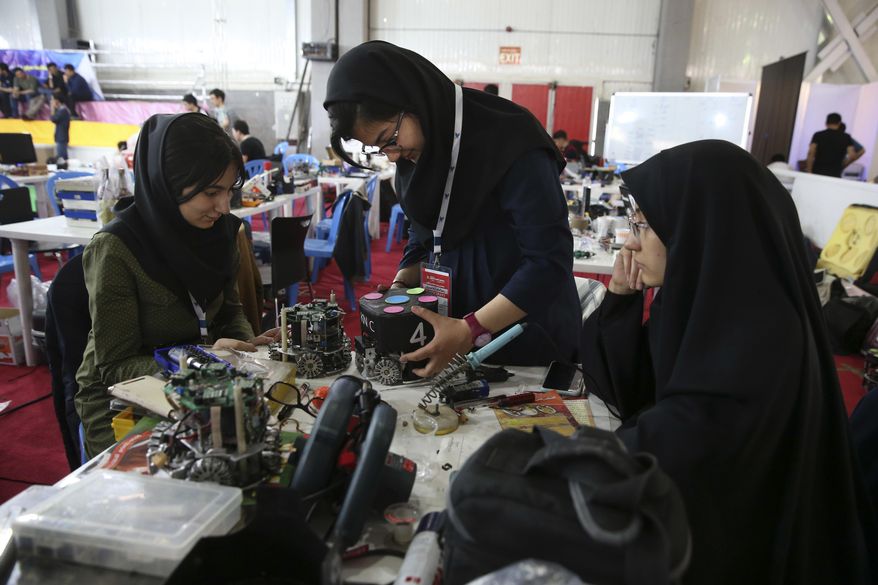 FILE - In this April 6, 2016, file photo, Iranian students prepare their robots during the international robotics competition, RoboCup Iran Open 2016, in Tehran, Iran. Universities in the U.S. say President Donald Trump&#x27;s revised travel ban would block hundreds of graduate students who play key roles in research. Twenty-five of America&#x27;s largest universities told The Associated Press they&#x27;ve sent acceptance letters to more than 500 students from the six banned countries for next fall, mostly from Iran, who are known for their strength in engineering and sciences. (AP Photo/Vahid Salemi)
