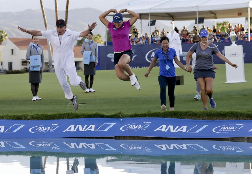FILE - In this April 3, 2016, file photo, Lydia Ko, of New Zealand, in pink, forms a heart as she jumps into the lake alongside her caddie, Jason Hamilton, left, after winning the LPGA Tour ANA Inspiration golf tournament at Mission Hills Country Club,in Rancho Mirage, Calif. The world's No. 1-ranked player hopes to get back on a winning roll when she returns to the ANA Inspiration this week. By (AP Photo/Gregory Bull, File)
