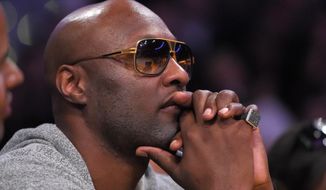 FILE - In this March 30, 2016, file photo, former Los Angeles Lakers&#39; player Lamar Odom watches during the second half of an NBA basketball game between the Lakers and the Miami Heat in Los Angeles. Odom told Us Weekly for a story published online March 29, 2017, that he is “a walking miracle” after being found unconscious with cocaine in his system in a Nevada brothel in 2015. (AP Photo/Mark J. Terrill, File)