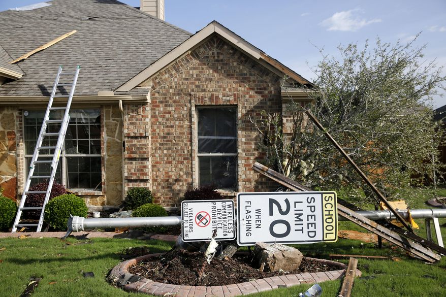 A sign lays in the yard of a damaged home following a storm in the early hours of the morning in Rockwall, Texas on Wednesday, March 29, 2017. A powerful storm system with winds exceeding 60 mph has damaged homes in suburban Dallas, knocked out power to tens of thousands across Texas and brought heavy rain that inundated some areas. (Rose Baca/The Dallas Morning News via AP)